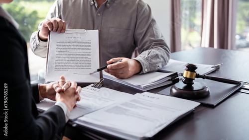 Male lawyer showing contract and pointing the signature box for signing while explaining and consultation about legislation agreement and terms data of business contract to businessman in law firm