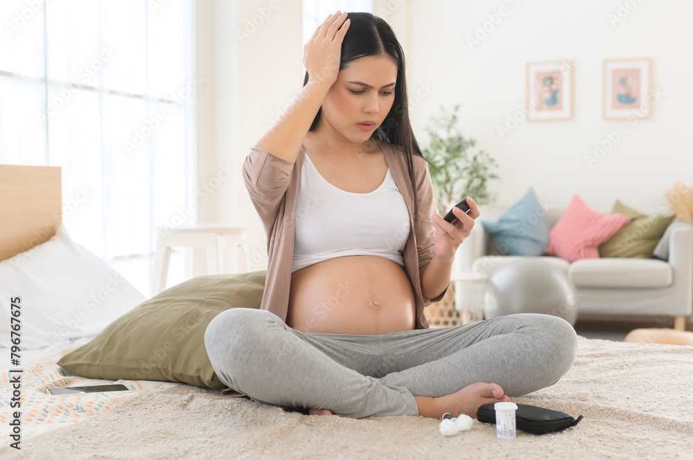 Pregnant woman checking blood sugar level by using Digital Glucose meter, health care, medicine, diabetes, glycemia concept