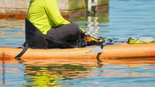 Woman preparing for paddle on board at calm lake water during warm summer. Stand up paddle board with wet suit and life jacket for paddling. Paddle SUP board sport and active recreation. photo