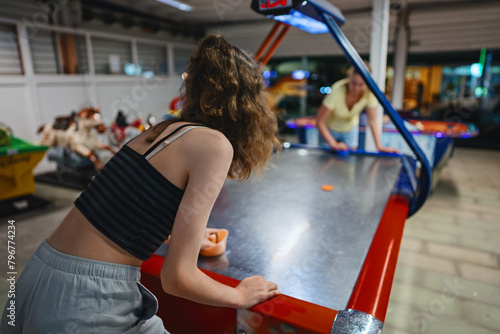 Family plays air hockey in the entertainment center. photo