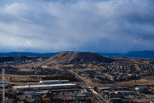 2022-12-21 A VIEW OF CASTLE ROCK FROM ROCK PARK WITH A FLAT TOP MOUNTAIN IN THE DISTANCE AND A INDUSTRIAL REA IN THE FOREGROUND IN COLORADO