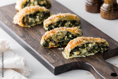 Golden brown, sesame seed topped spinach and feta pastries, ready for sharing.