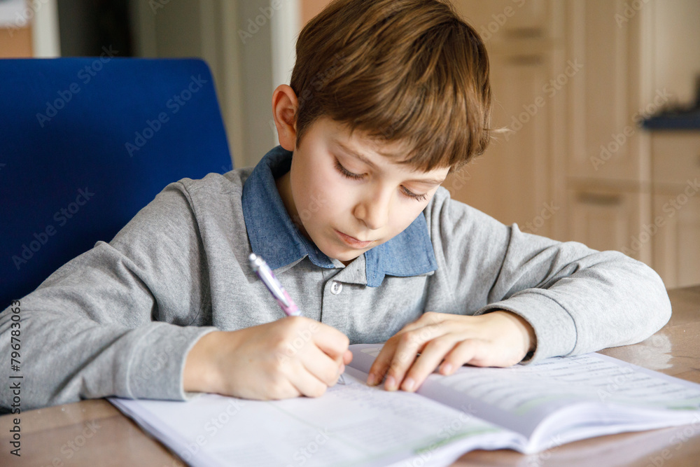 Upset school kid boy making homework during quarantine time from corona pandemic disease. Crying and sad boy frustrating staying at home. Upset school kid boy making homework during quarantine time from corona pandemic disease. Crying and sad boy frustrating staying at home.