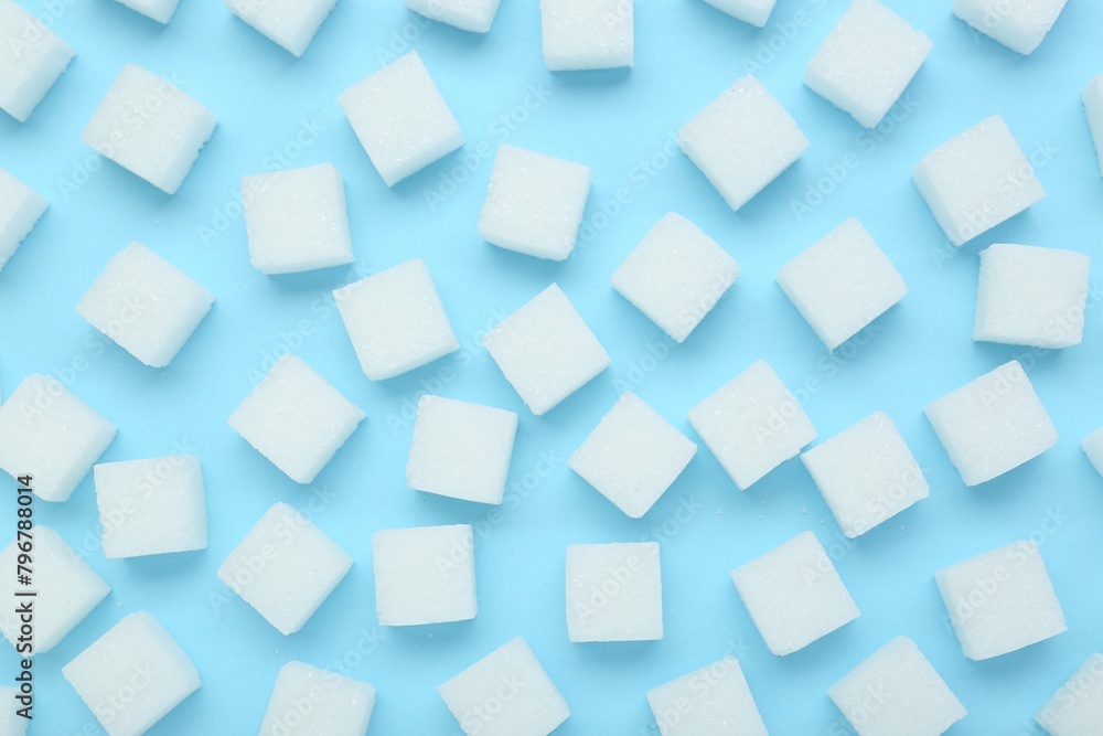 White sugar cubes on light blue background, top view