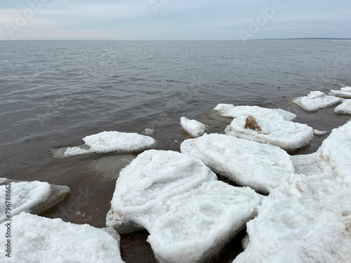 White ice floes float on the surface of the water. Spring ice drift.