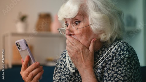 Humorous elderly woman astonished by shocking news she saw on her cellphone