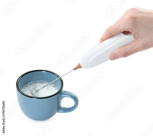 Woman whisking milk in cup with mini mixer (frother wand) isolated on white