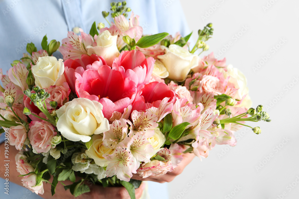 Woman with beautiful bouquet of fresh flowers on light background, closeup Woman with beautiful bouquet of fresh flowers on light background, closeup