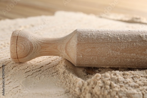 Flour and rolling pin on table, closeup