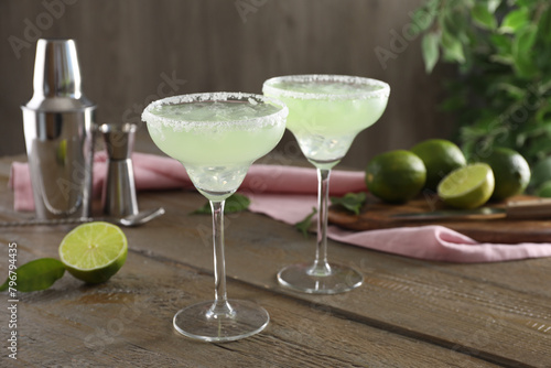 Delicious Margarita cocktail in glasses on wooden table, closeup