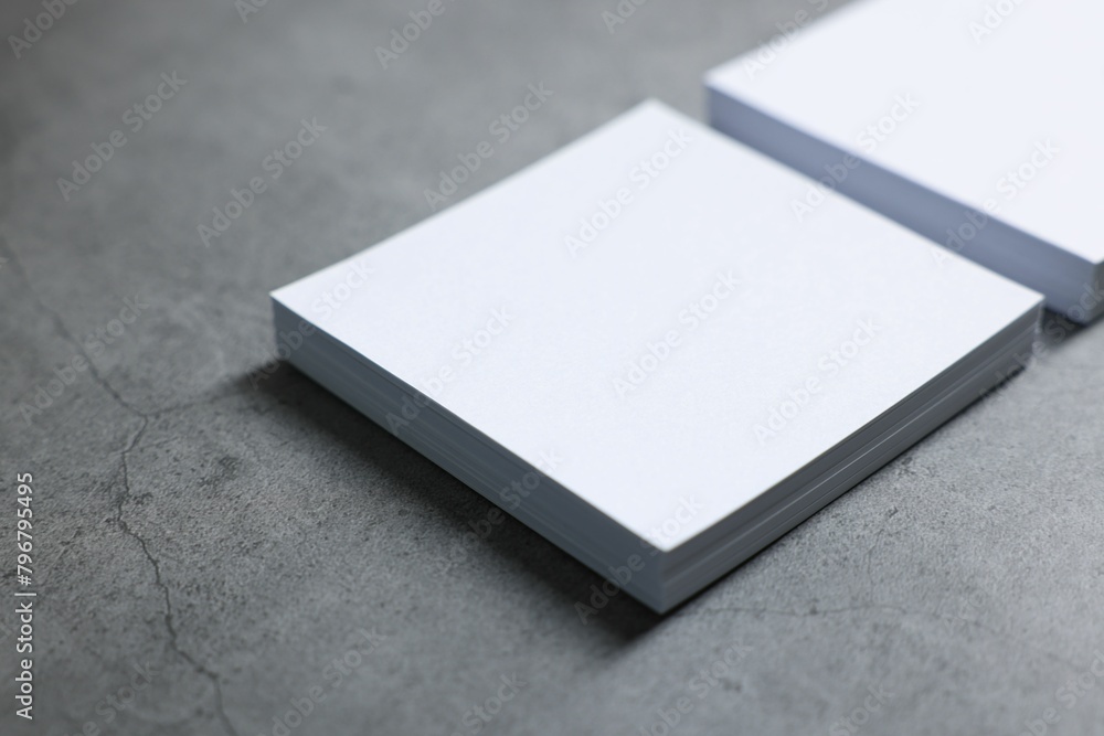 Blank paper sheets on grey textured table, closeup. Mockup for design Blank paper sheets on grey textured table, closeup. Mockup for design
