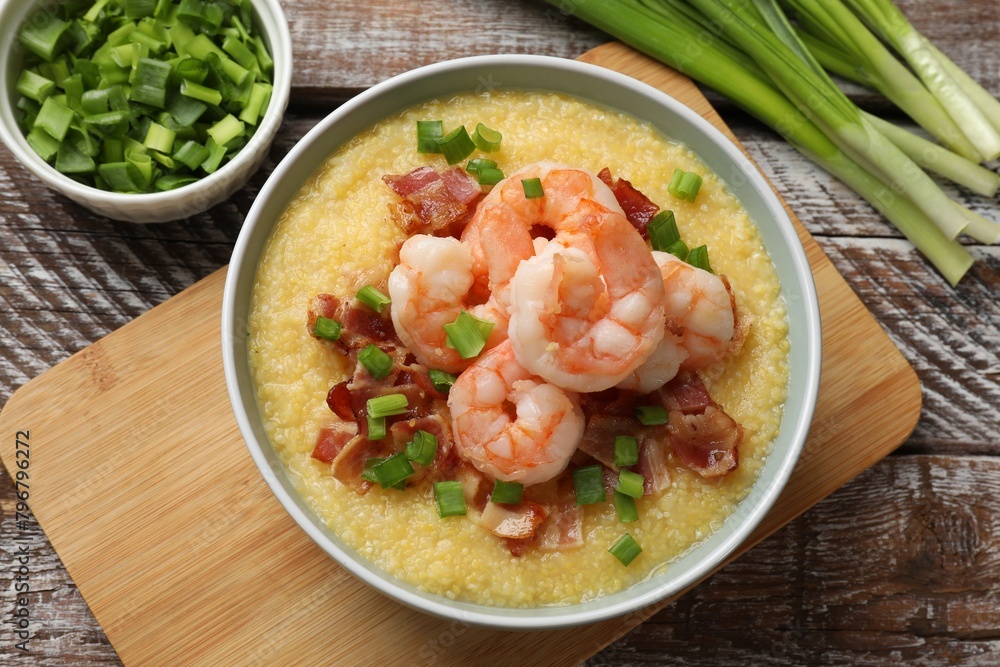 Fresh tasty shrimps, bacon, grits and green onion in bowl on wooden table, flat lay Fresh tasty shrimps, bacon, grits and green onion in bowl on wooden table, flat lay