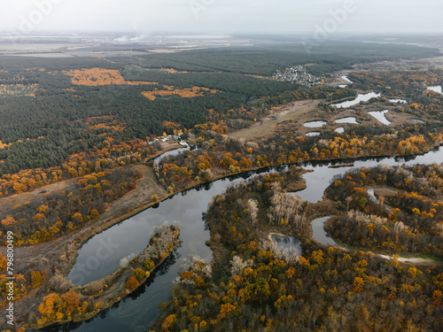 Aerial autumn river curves in colorful autumn with villages on riverbank in Ukraine