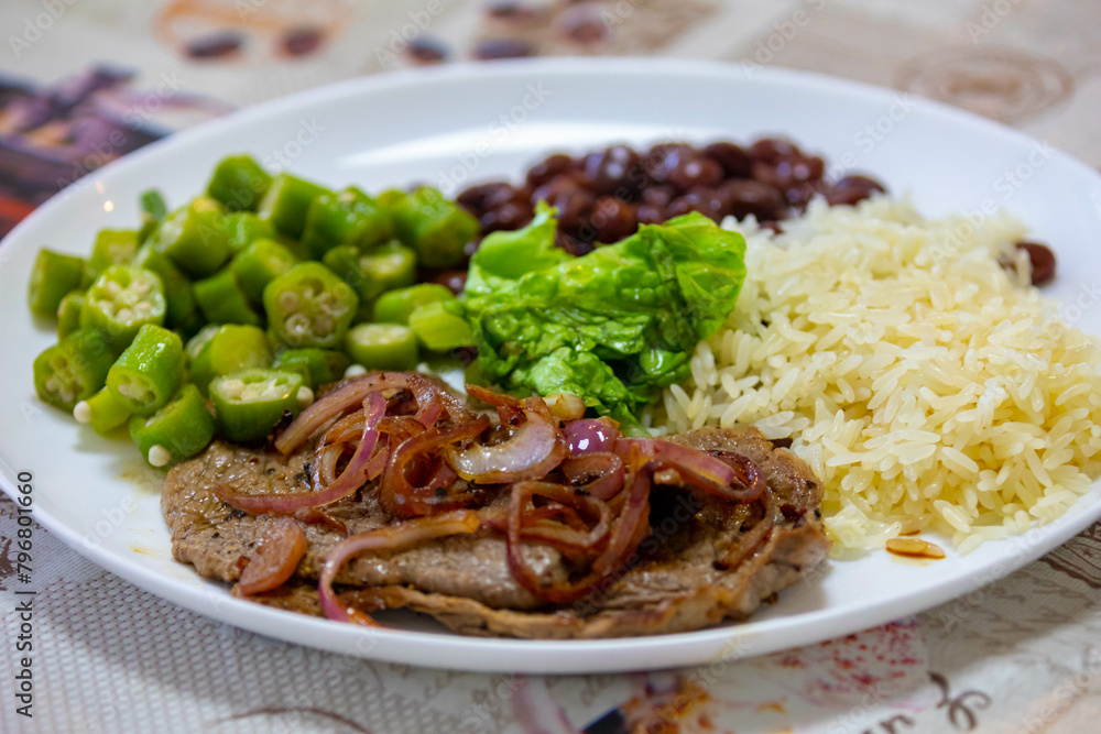 Traditional rustic Brazilian lunch, beans, rice, steak, okra and lettuce. Executive made dish Traditional rustic Brazilian lunch, beans, rice, steak, okra and lettuce. Executive made dish