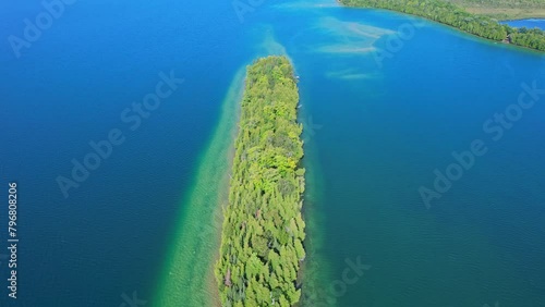 Small island with retreat cottage or cabin surrounded by clean waters of the lake. North American sunny summer day. Famous Canadian tourist vacation routs. photo