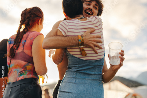 Friends hugging upon meeting at a fun summer festival photo
