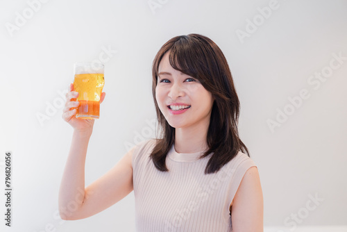 笑顔でビールを飲む若い女性