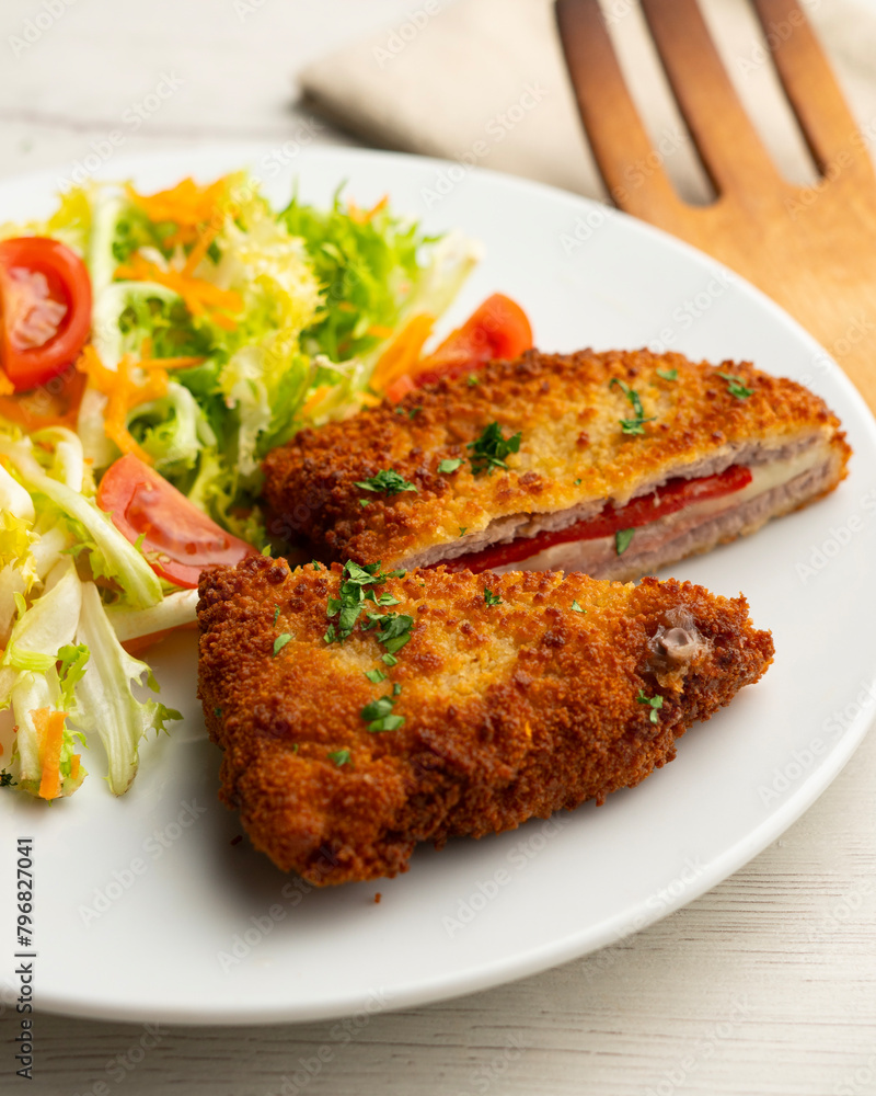 Cachopo is a Spanish dish that consists of two breaded beef fillets stuffed with cheese and serrano ham. Cachopo is a Spanish dish that consists of two breaded beef fillets stuffed with cheese and serrano ham.