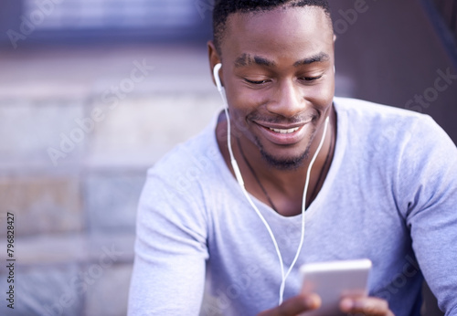 Happiness, black man and phone with earphones for music, streaming and podcast for relax in city. Male college student, smile and mobile for communication, social media and headphones for audio