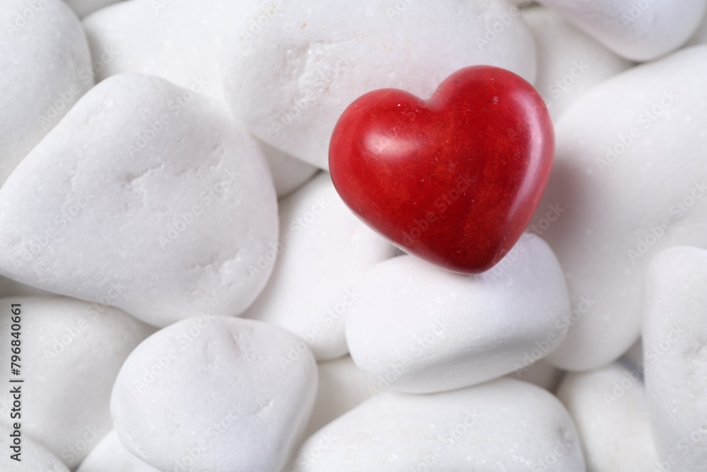 Obraz premium Decorative heart on white pebble stones, top view
