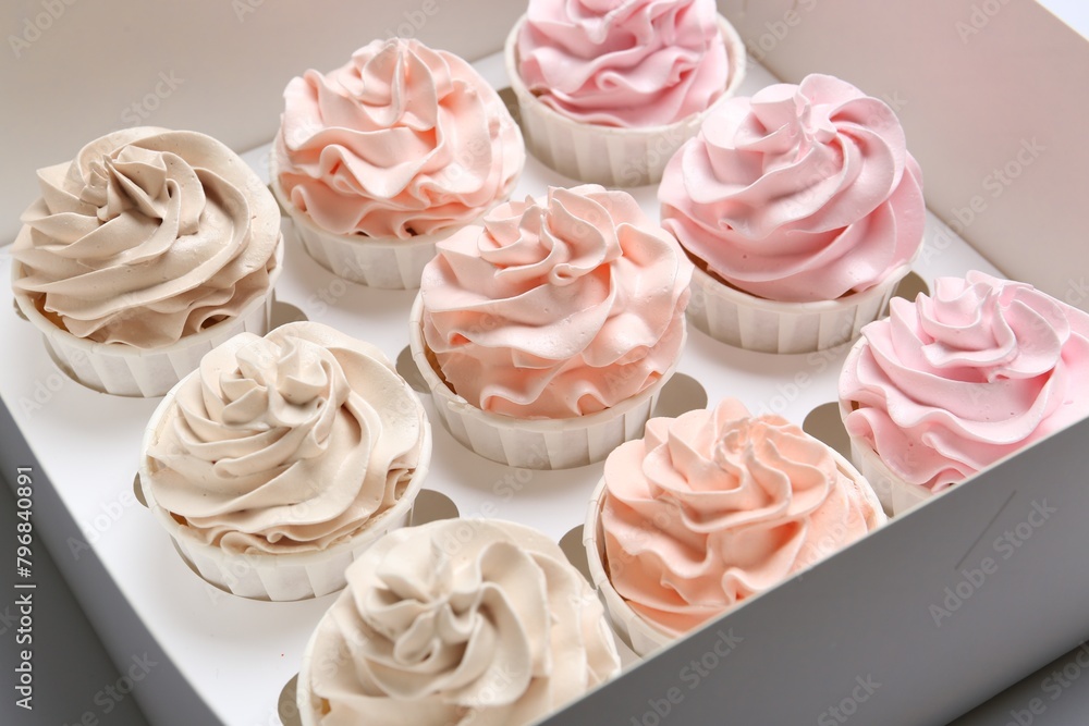 Fototapeta premium Many tasty cupcakes with colorful cream in box, closeup