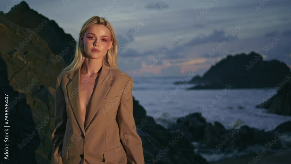 Travel girl posing rocky coast on summer night. Attractive blonde modeling shore Travel girl posing rocky coast on summer night. Attractive blonde modeling shore