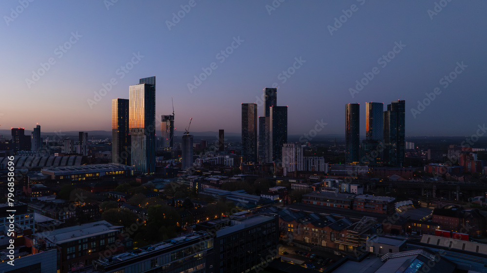 Twilight Manchester cityscape with illuminated skyscrapers