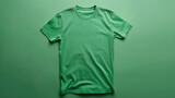 Front view of a plain green t-shirt on a matching green background. The shirt is made of a soft, lightweight fabric and has a relaxed fit.