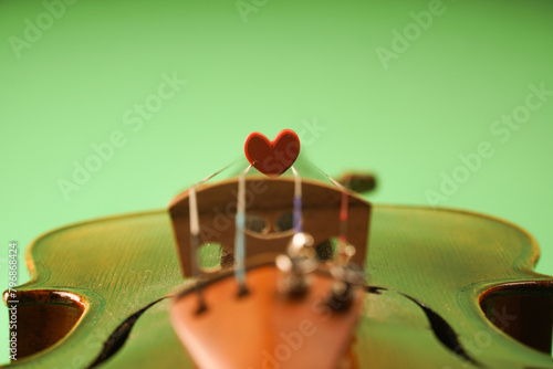A photo that symbolizes love for music. A red heart lies on the strings of a violin
