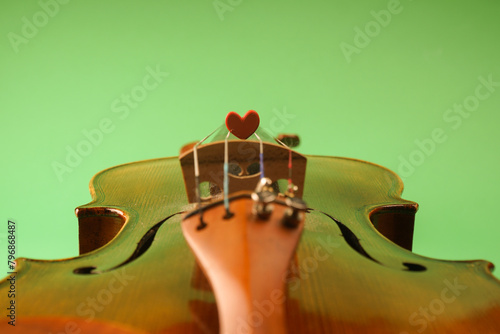 A photo that symbolizes love for music. A red heart lies on the strings of a violin

