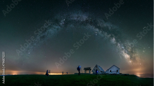 Group of photographers capture the Milky Way over the abandoned buildings at the top of Picon Blanco, in Espinosa de los Monteros, Burgos, a cloudless night with a starry sky photo