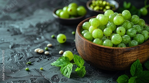 rustic wooden bowl with green grapes on dark background © YuliiaMazurkevych