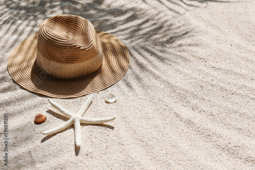 Summer vibes. Broad brim straw hat and sunglasses on a sandy beach. Copy space for text. © Evrymmnt