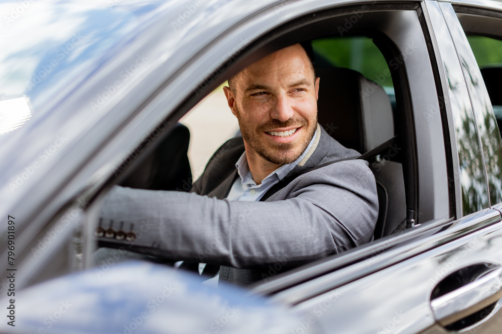 Smiling man enjoying a sunny drive in a modern car interior Smiling man enjoying a sunny drive in a modern car interior
