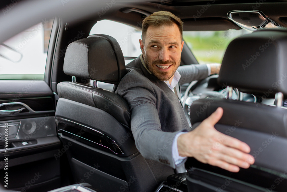 Welcoming smile from a joyful driver in a luxury sedan on a sunny day