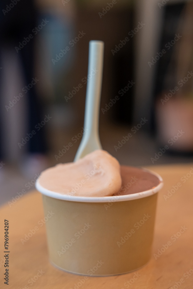 A cup of Gelato, Ice-cream on the table with blur background in a shop A cup of Gelato, Ice-cream on the table with blur background in a shop