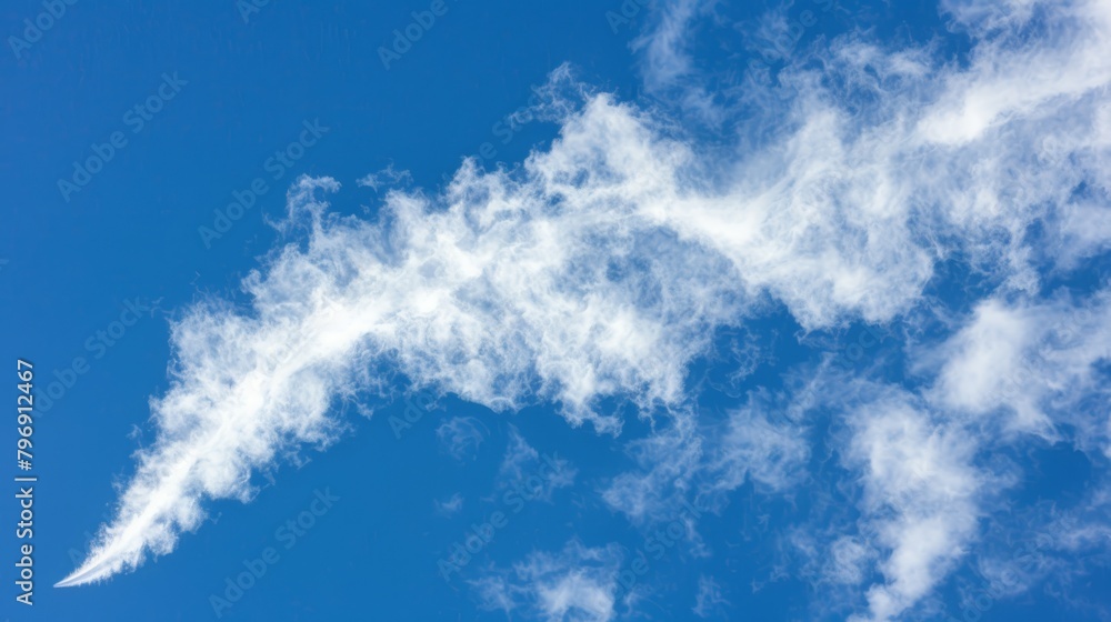 A plane flies against a backdrop of blue sky, its path trailing a cloud resembling a bird in formation A plane flies against a backdrop of blue sky, its path trailing a cloud resembling a bird in formation