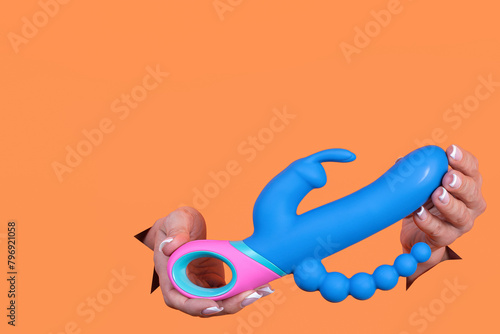A sex toy. Vibrator on an orange background. Leisure for adults. Copy space