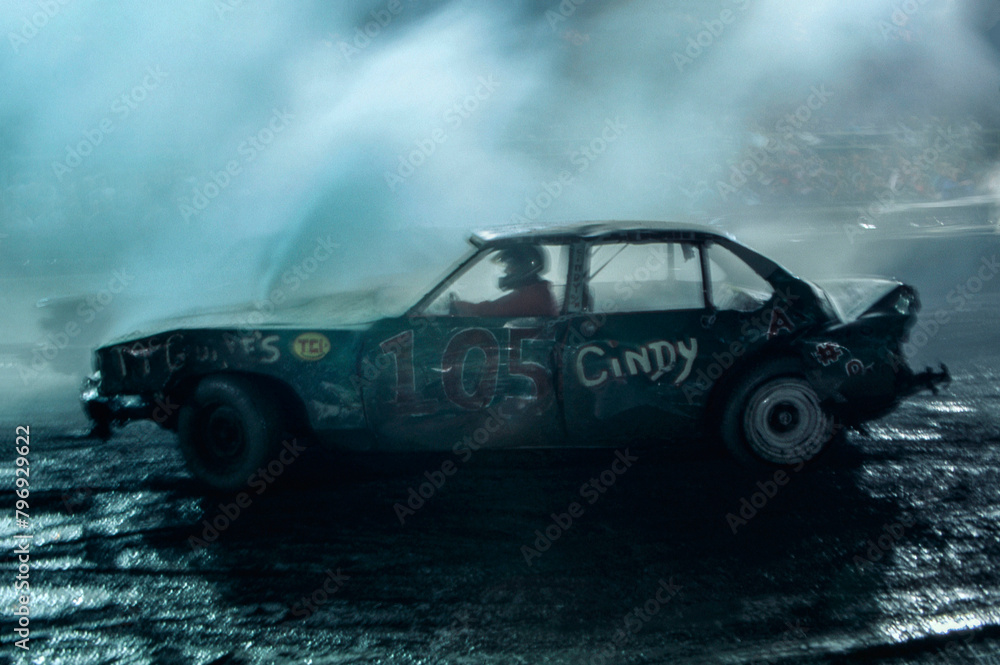Demolition derby at night with smoke and car