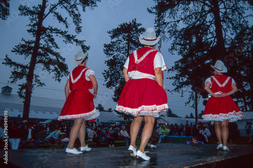 Dancing performance by three women in red dresses and white cowboy hats at the County Fair.