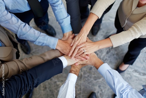 Unity in business: top view of teams hands together signifying collaboration and commitment