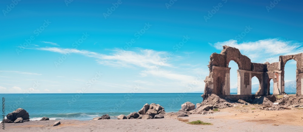 Beach with imposing rock formation under clear sky