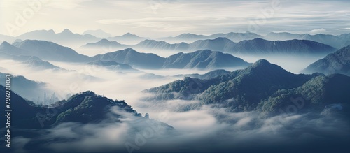 Mountains shrouded in mist under a clear blue sky © Ilgun