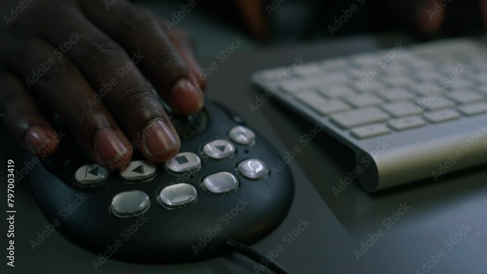 Close-up of hands of anonymous African American male video editor typing on computer keyboard and using professional ergonomic multimedia controller, while working on design project Close-up of hands of anonymous African American male video editor typing on computer keyboard and using professional ergonomic multimedia controller, while working on design project