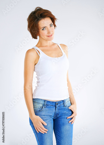 Woman, portrait and tank top for fashion in studio with confidence, attitude and jeans for trendy style. Girl, organic cotton and vest made of recycling fabrics for capsule wardrobe and mockup space.