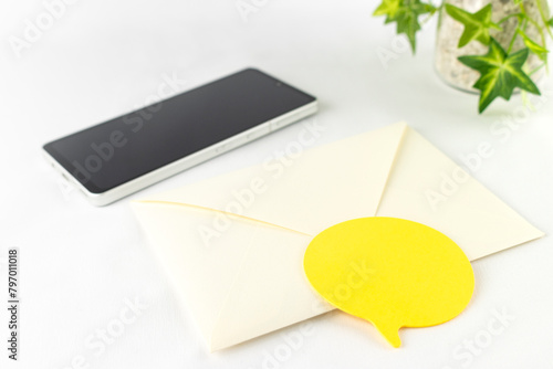 スマートフォンと封筒と付箋。メールやSNSのイメージ