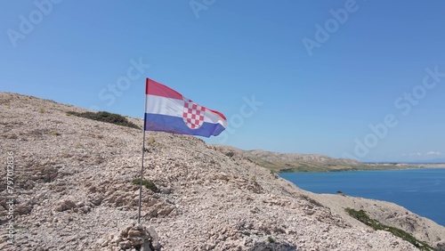 Obraz na plátně Croatian flag waiving on a sunny summer day on the top of a cliff with island archipelago
