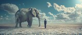 A man stands in front of a huge elephant in a desert