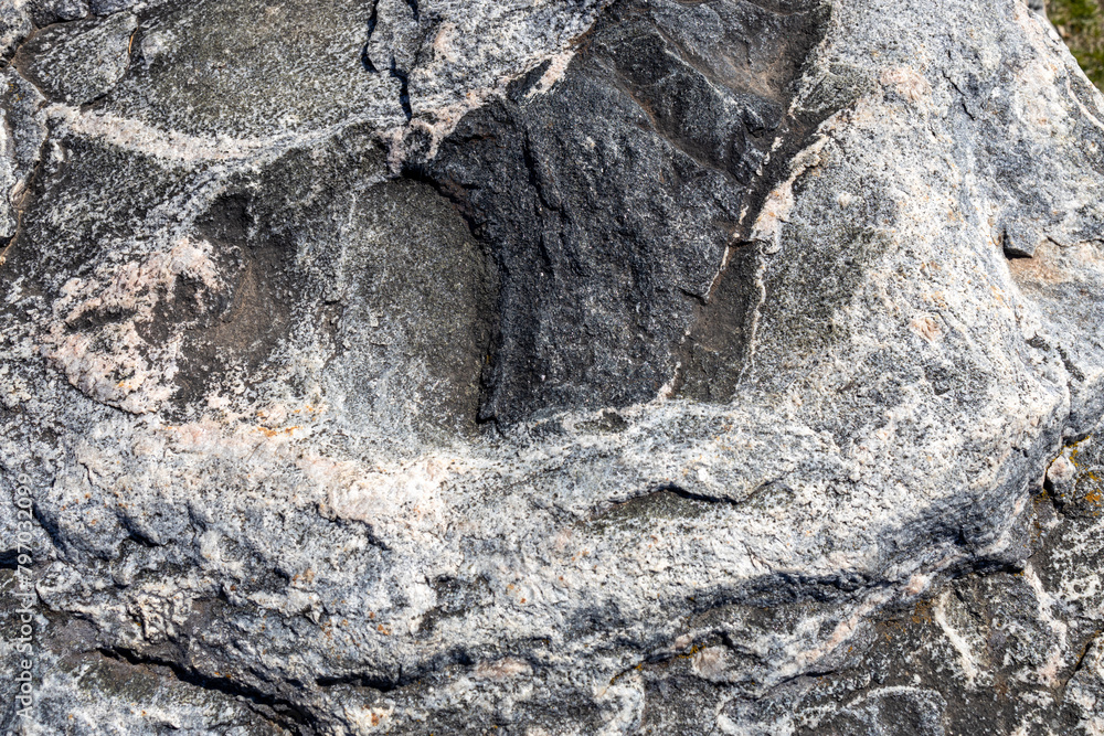 Naklejka premium Full frame abstract texture background of the textured surface on a large striated granite rock