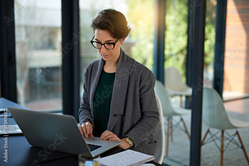 Lawyer, woman and laptop in office for legal planning, policy review or feedback on visa status. Attorney, immigration and female person in workplace for networking, online or asylum seekers aid